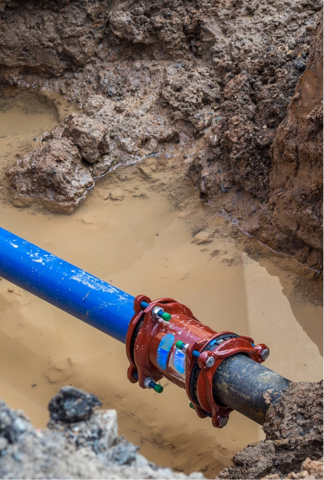 Close-up of a heavy-duty red mechanical coupling installed by Drainstar Plumbing Inc. on a blue water pipe